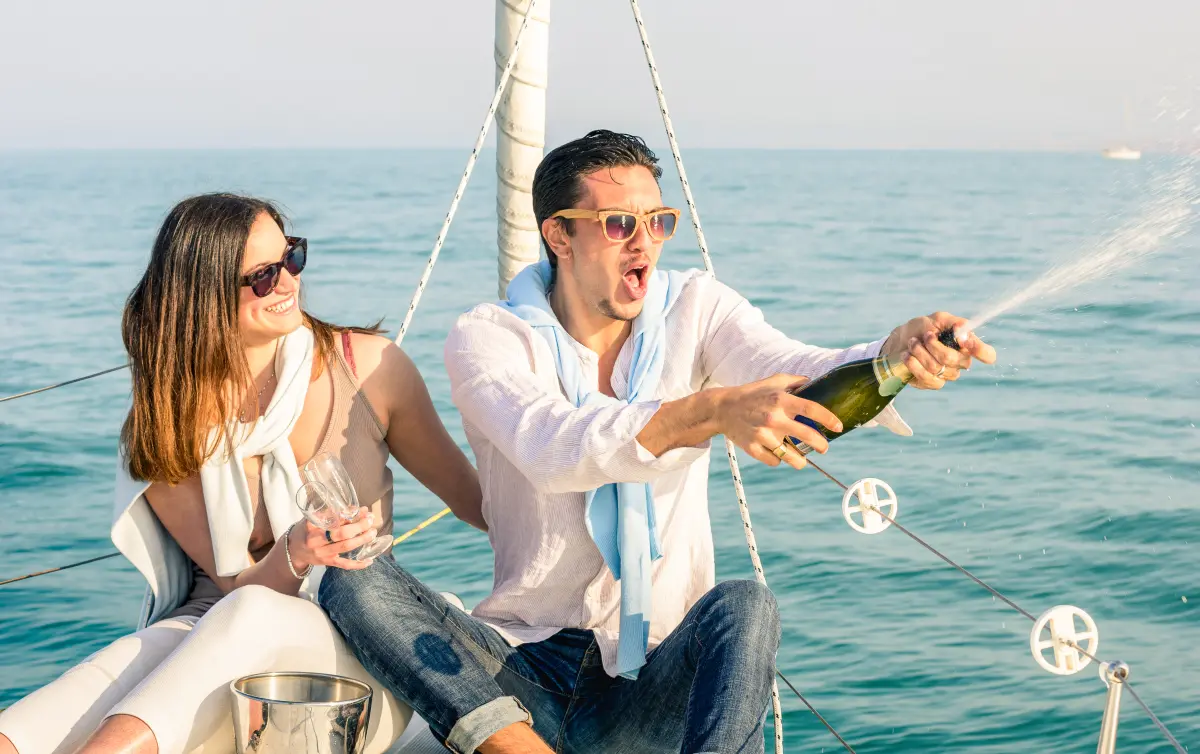 sekt_prosecco_champagner_junges_paar_Boot_jacht_oeffnet_flasche