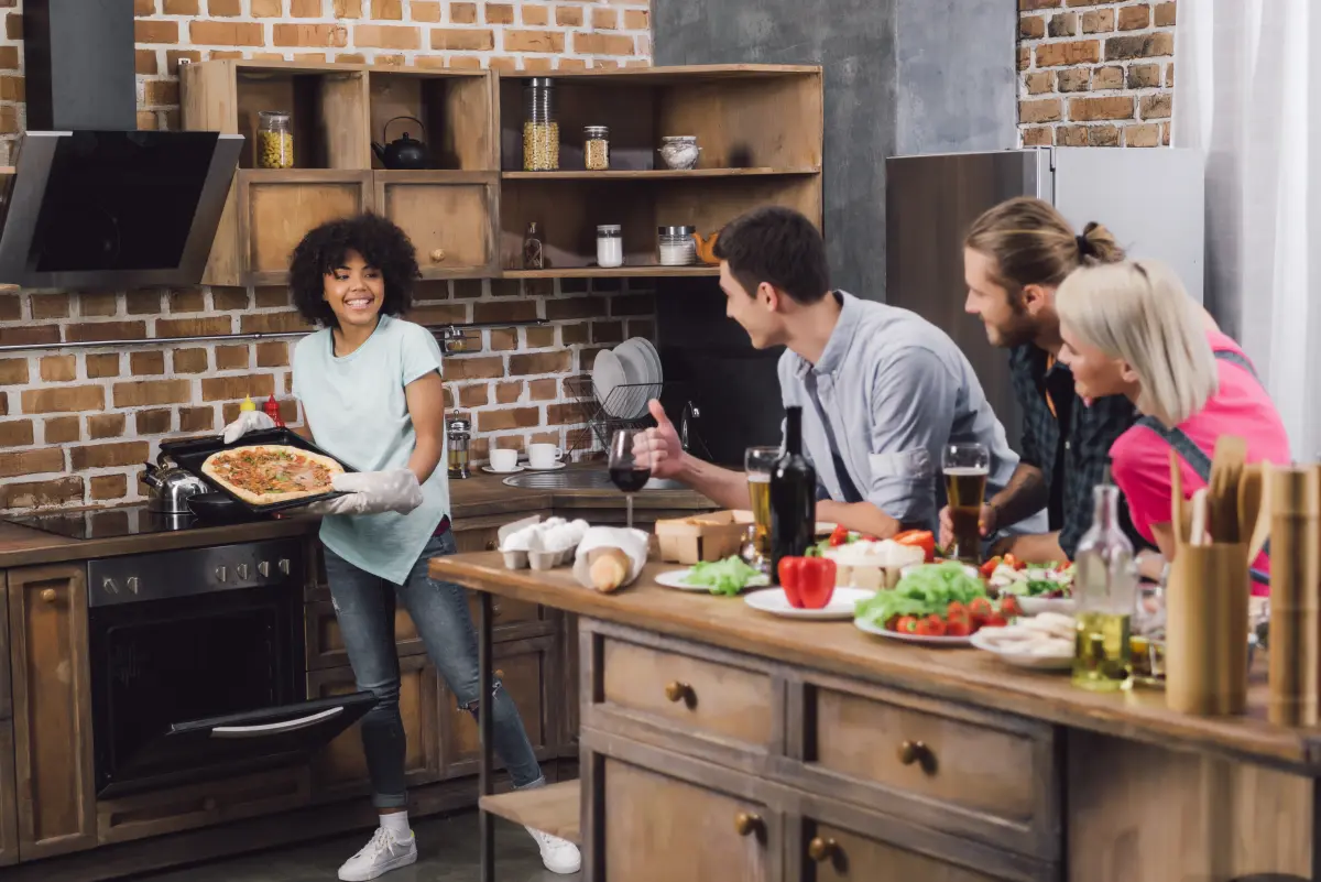 kuechenparty_maenner_frauen_pizza_kochen_gemuese_wein_essig_oel