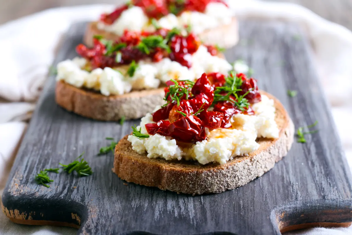 tomaten_getrocknet_brot_ricotta_olivenoel_holzbrett