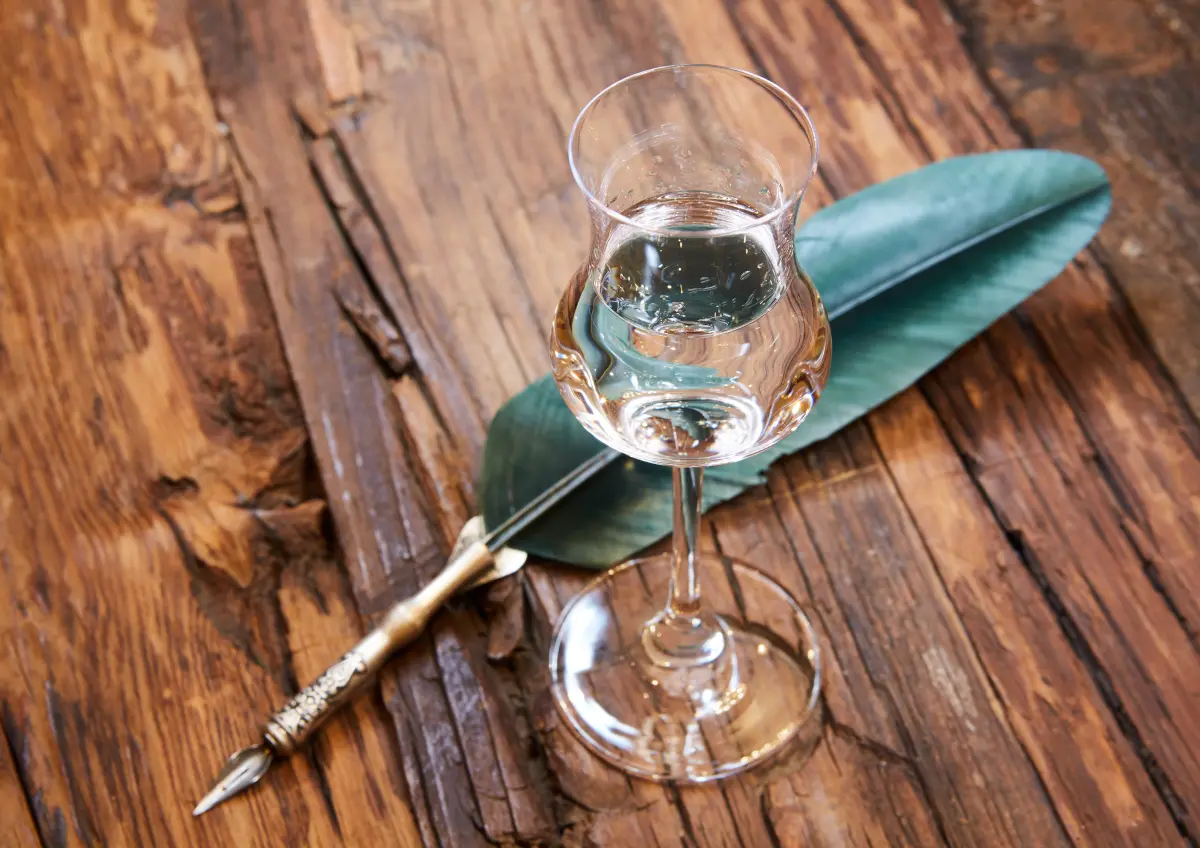 grappa_glas_holztisch_schreibfeder