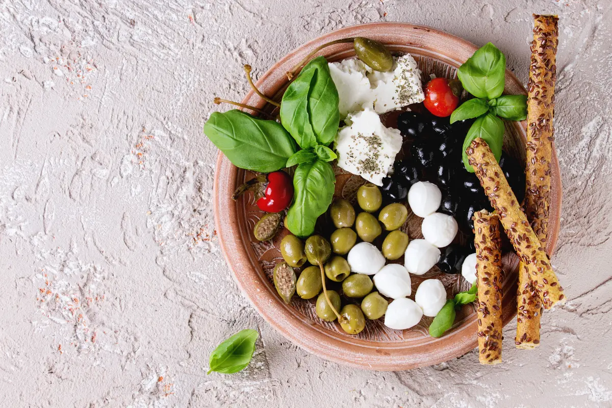 gruene_oliven_mediterran_vorspeise_feta_mozzarella_grissini_basilikum